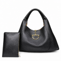 A black pebbled leather hobo handbag with a gold-tone horsebit hardware accent, shown alongside a matching black zip-around wallet on a white background.